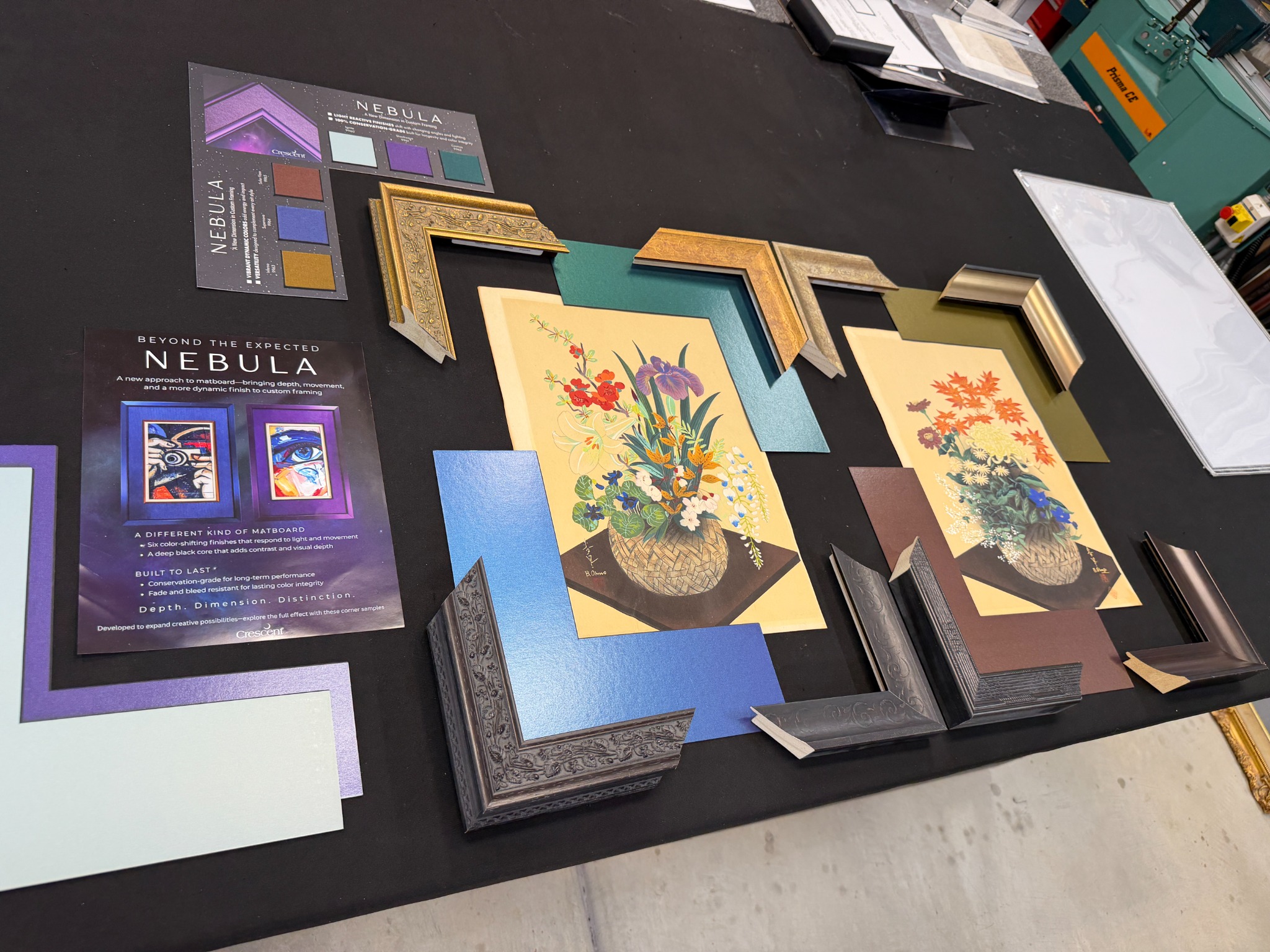 Artwork, matboard colors, and frame moulding samples arranged on the Villa design table